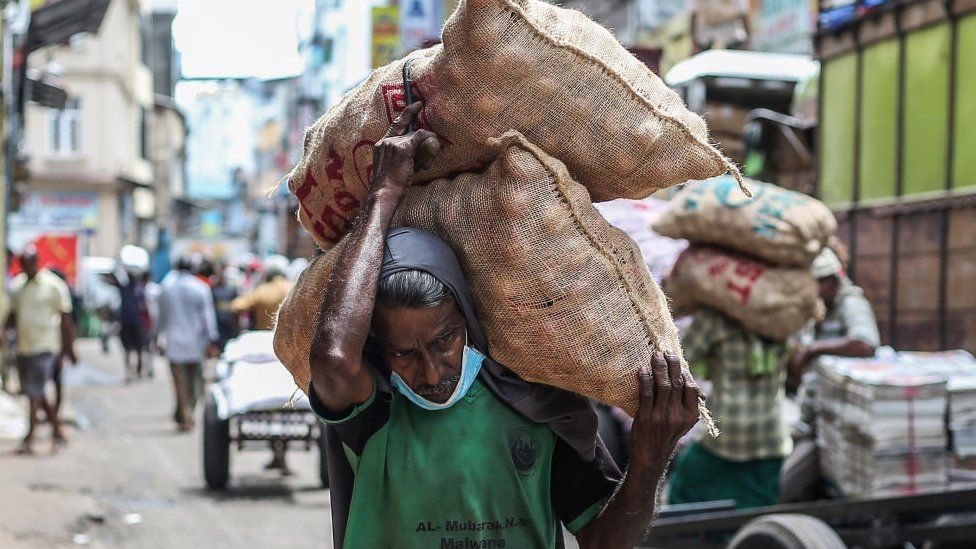 一名工人在科伦坡的佩塔地区搬运一袋袋洋葱