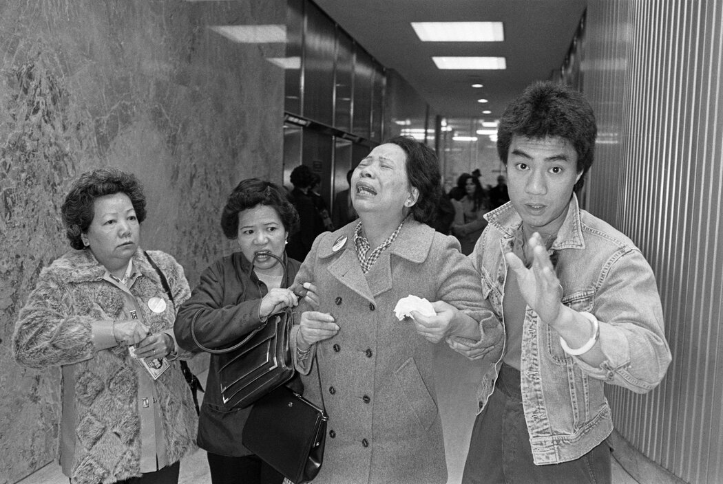 陈余琼芳的儿子陈果仁被两名白人男子用棒球棒打死，1982年6月，亲戚搀扶崩溃的她离开底特律市县大楼。