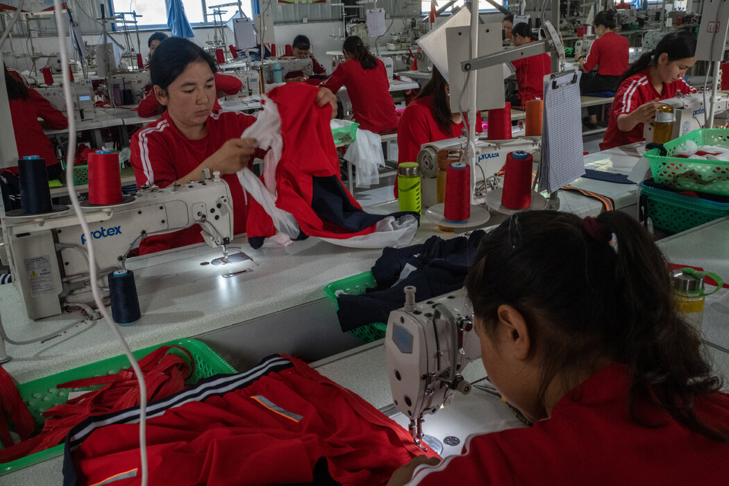 2019年，中国新疆一家工厂的维吾尔工人。目前，来自新疆的大量原材料和零部件进入中国或其他国家的工厂，然后再进入美国。