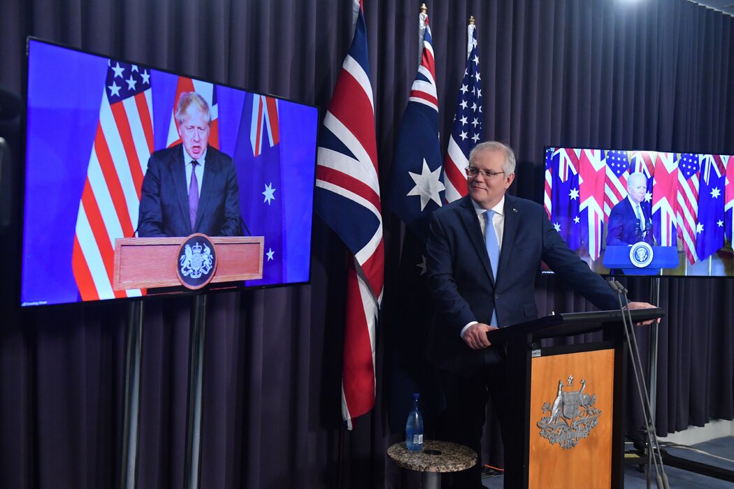 2021年，澳大利亚前总理莫里森在堪培拉听英国首相约翰逊发表讲话，他们正在与美国总统拜登举行联合在线新闻发布会。